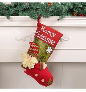 Close-up of a 3D Santa Claus plush stocking hanging on a white festive fireplace mantle