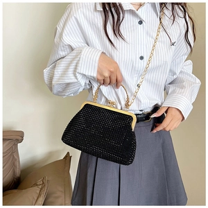 Close-up of black sequined evening bag with sparkling rhinestones and gold hardware