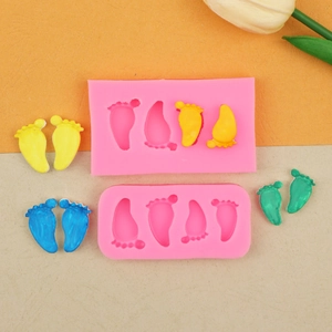 Détail du moule en silicone rose avec formes de pieds de bébé 3D pour l'argile et le chocolat