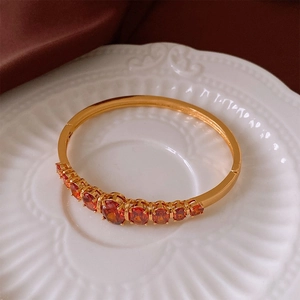 Vue détaillée de neuf pierres précieuses rouge orangé sur un bracelet doré vintage