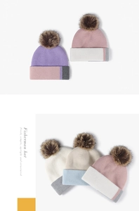Detail of ribbed knit beanies with fluffy pom poms and contrasting stripes in soft colors