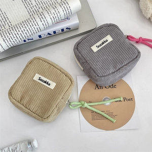 Detailed texture of gray and khaki corduroy mini cosmetic bags with zippers and lanyards