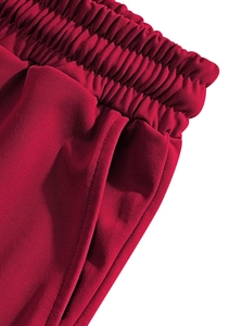 Detailed macro view of red linen pants showing elastic waistband and side pocket stitching