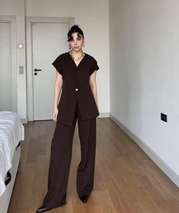 Detail of deep brown two-piece set featuring V-neck waistcoat and wide-leg trousers