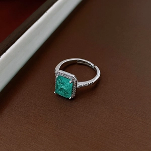 Detail of silver open ring with emerald green square zircon and sparkling pavé accents