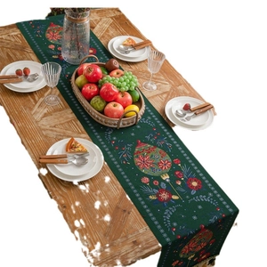Dark green Christmas tree table runner with jacquard tassels on a rustic wooden dining table