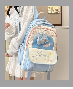 Detail of light blue and white patchwork backpack with a small polka dot coin purse