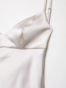 Close-up of champagne satin slip dress featuring V-neckline and adjustable spaghetti straps