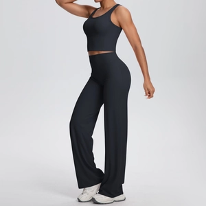 Dettaglio del set yoga nero con pantaloni a vita alta a gamba larga e crop top