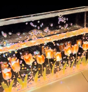 Close-up of DIY tulip night light with glowing orange petals and purple glitter sand