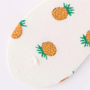 Detailed view of white cotton crew socks featuring vibrant yellow and green pineapple patterns