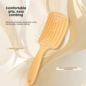 Detail of ergonomic handle and hollow vent design on an orange curved styling hairbrush