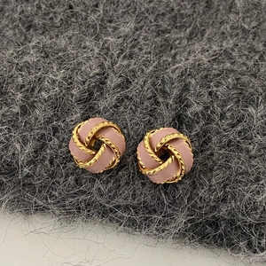 Detail of vintage French knot earrings with pink enamel and gold plated finish
