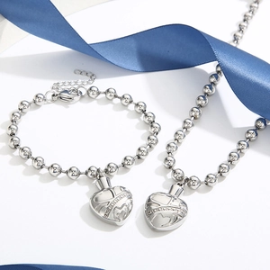 Close-up of heart locket pendant with bead chain and blue ribbon decoration