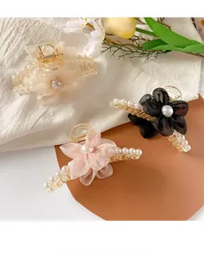 Detailed view of elegant mesh flower hair claws with pearls in cream, pink and black