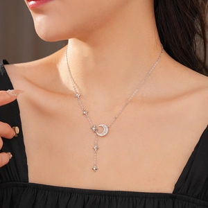 Detail of silver moon and star pendant necklace with cubic zirconia on a model