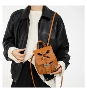 Détail du mini sac à dos en cuir marron avec découpe papillon et boucles métalliques