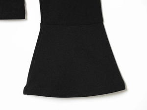 Detail of black high-density knit fabric showing flared hem and precise stitching