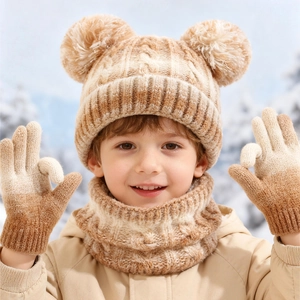 Close-up of children's warm knit hat, scarf and gloves set with soft double pom-poms