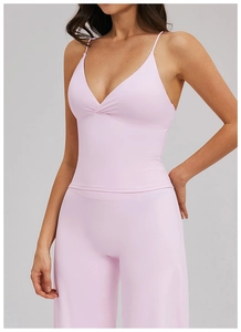 Détail d'un ensemble de yoga rose clair avec bretelles fines et tissu doux élastique