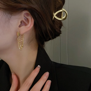 Elegant gold double chain drop earrings worn by a model in a minimalist fashion style