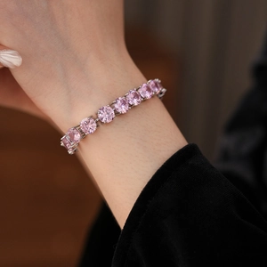Close-up of a pink round-cut cubic zirconia tennis bracelet with silver prong setting