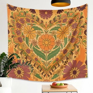 Detailed view of bohemian floral tapestry with orange and yellow heart patterns on a wall