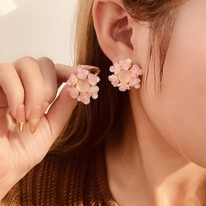 Sweet pink resin flower stud earrings with silver needles shown worn by a model