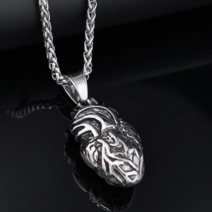 Gros plan du pendentif cœur anatomique en argent avec texture métallique en relief