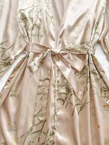 Detail of satin floral robe with smooth fabric texture and elegant botanical print