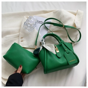 Détail du sac à main vert à texture litchi avec fermoir et foulard en soie imprimé élégant