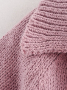 Close-up of pink knit fabric texture showing high-quality stitching on V-neck top