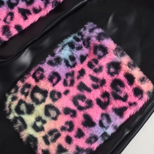 Dettaglio della trama in pelle nera con patchwork in ecopelliccia leopardata colorata sul capo