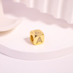 Macro shot of gold square letter A bead with sparkling pave-set cubic zirconia stones