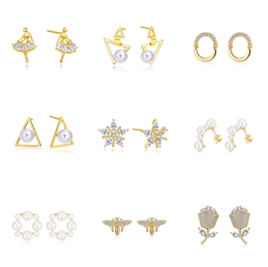Close-up of gold plated 925 silver earrings with pearls and zircon in diverse shapes