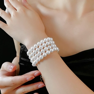 Gros plan d'un élégant bracelet à quatre rangées de perles blanches sur poignet