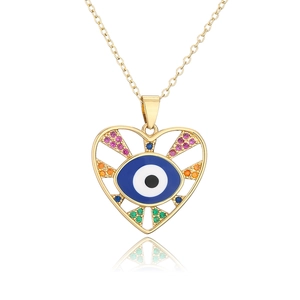 Macro detail of golden heart pendant with blue evil eye enamel and colorful zircons