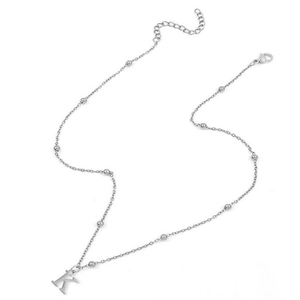 Detail of silver beaded necklace with capital letter K pendant and lobster clasp closure
