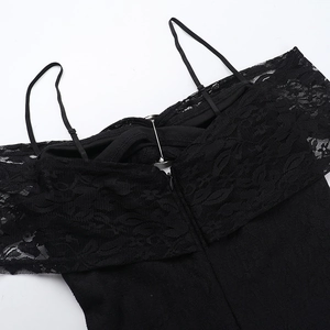 Dettaglio di un vestito in pizzo nero con motivi floreali e cerniera nascosta sul retro