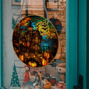 Detail of Halloween round acrylic pumpkin decor with iron chain hanging on a window