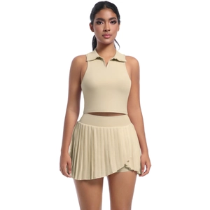 Dettaglio di un set sportivo beige con crop top a polo e gonna a pieghe da tennis
