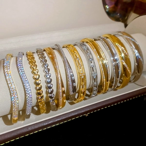 Detail of 18k gold plated bracelets with shimmering heart and wavy zircon pave patterns