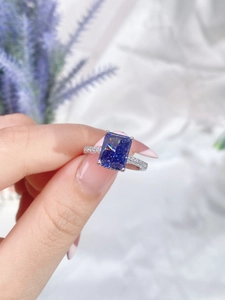 Macro shot of S925 sterling silver ring with blue emerald-cut gem and accent diamonds