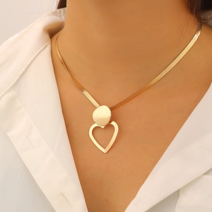 Elegant gold-tone flat snake chain necklace with heart pendant shown on model neck