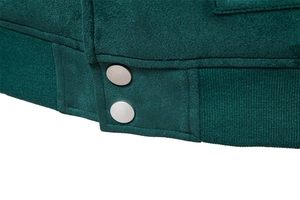 Détail d'une veste en daim vert foncé avec ourlet côtelé et boutons-pression en métal argenté