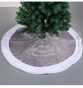 Macro detail of grey plush Christmas tree skirt with white embroidered festive lettering
