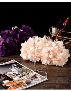 Detailed shot of dark purple and champagne floral evening clutch bags with metal ball clasp