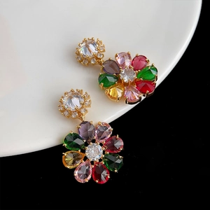 Gros plan détaillé de boucles d'oreilles fleurs dorées avec zircons colorés