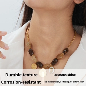 Detail of bohemian layered necklace with brown resin beads and gold coin pendants