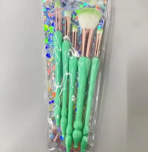 Vue détaillée de 5 pinceaux maquillage coquillage vert menthe avec bagues en or rose